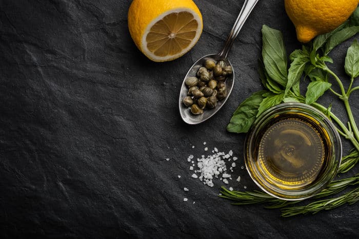 Image of capers with olive oil and half of a lemon