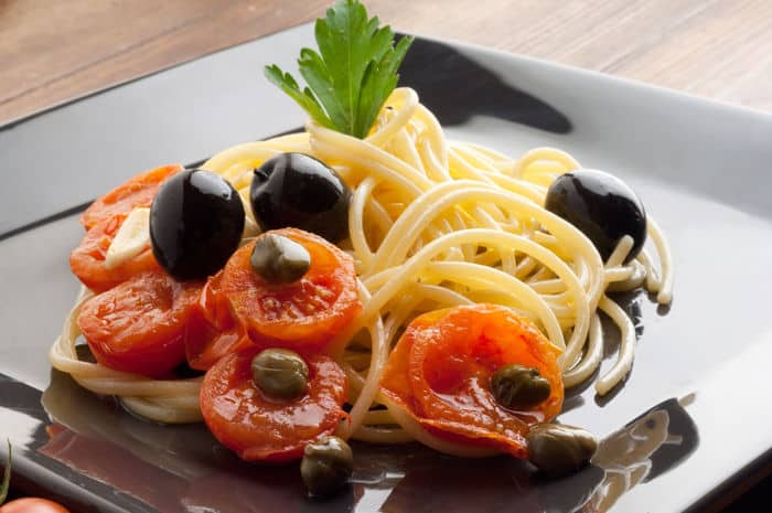 Image of a pasta dish with capers, tomatoes and olives