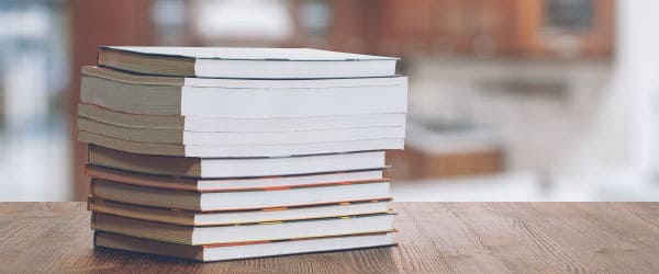 A stack of cookbooks on kitchen worktop