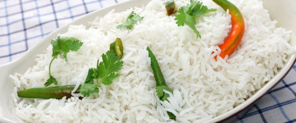 Plate of cooked basmati rice with cilantro and chillis