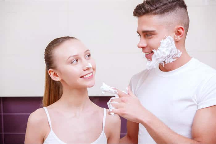 Couple doing morning routine with shaving cream